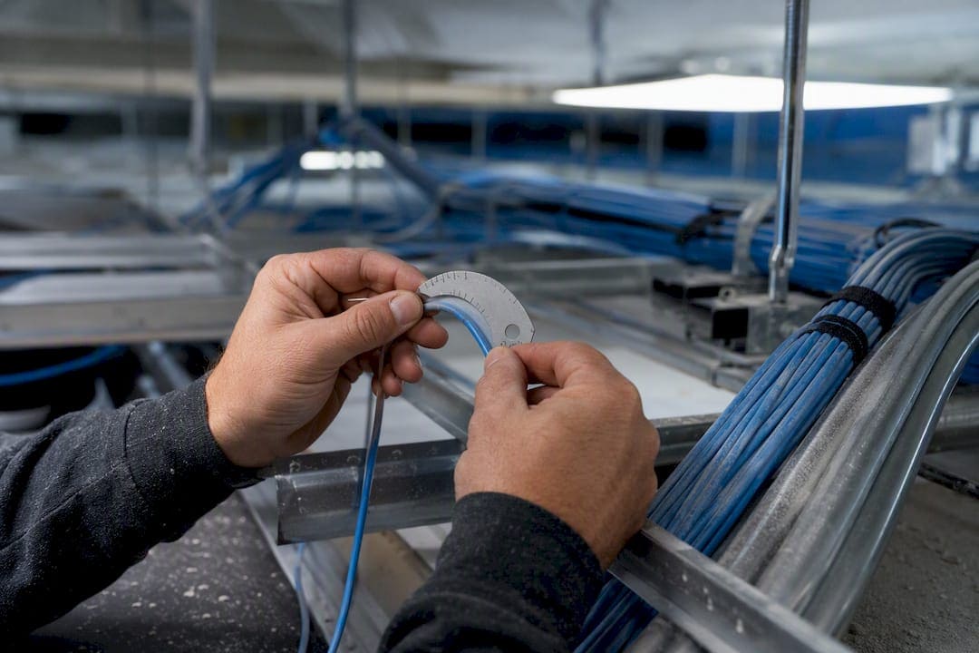 Hands measuring Cat6 cable bend radius