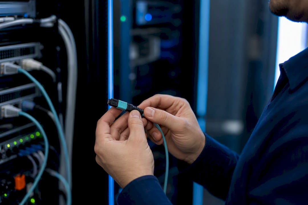 Technician carefully handling MPO fiber optic cable