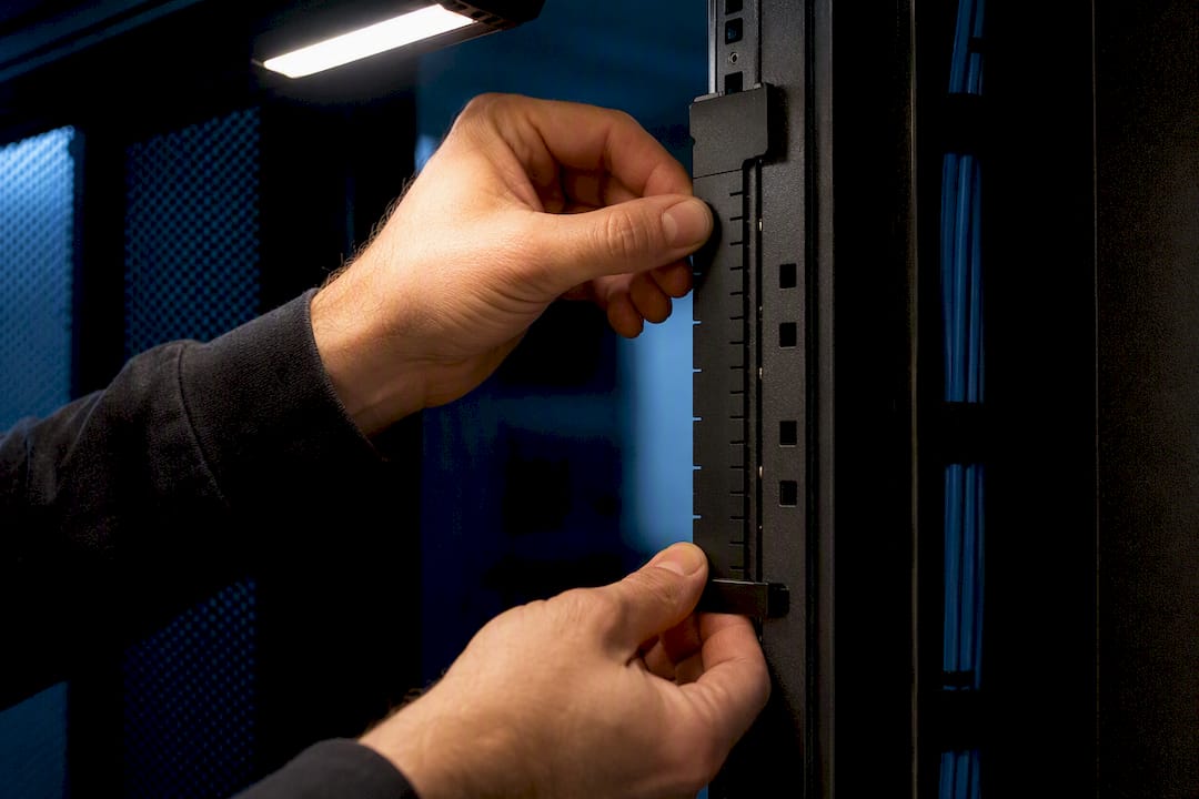 Technician measuring rack unit spacing