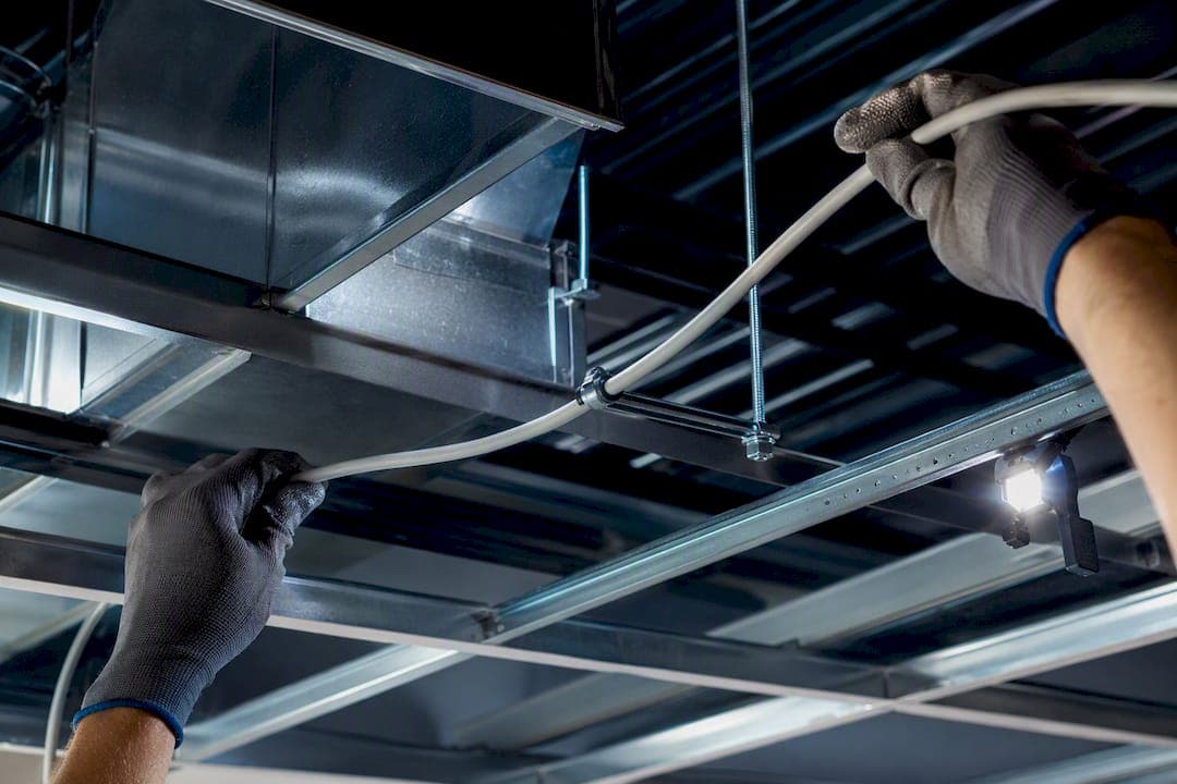Installer routing cable through ceiling plenum